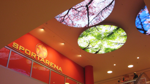 Illuminated fabric face ceiling discs in shopping mall