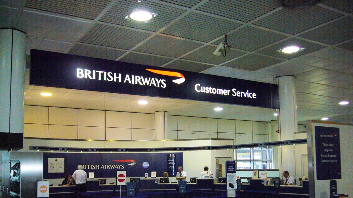 Illuminated sign above British Airways service desk at London Gatwick airport